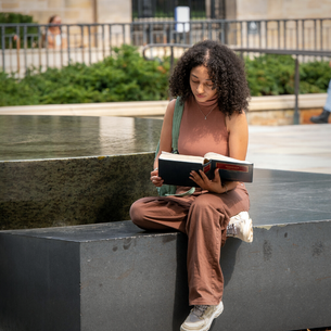 Student reads a law textbook next to the Yale Women's Fountain