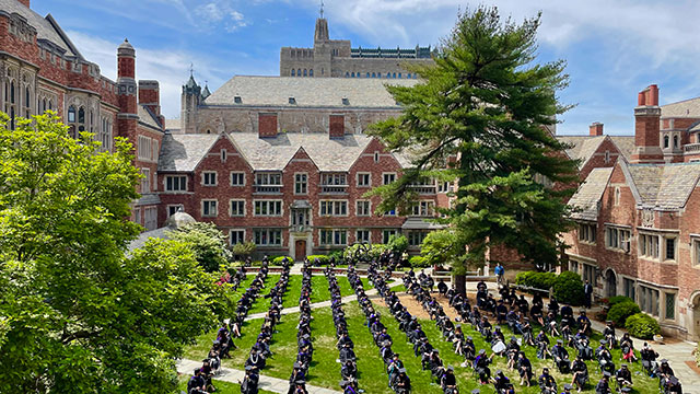 Aerial view of graduates seated on chairs in courtyard