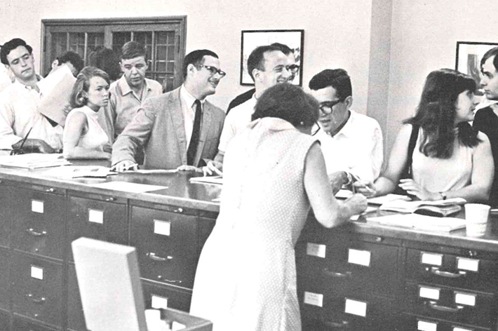 Students standing at counter in registrar's office