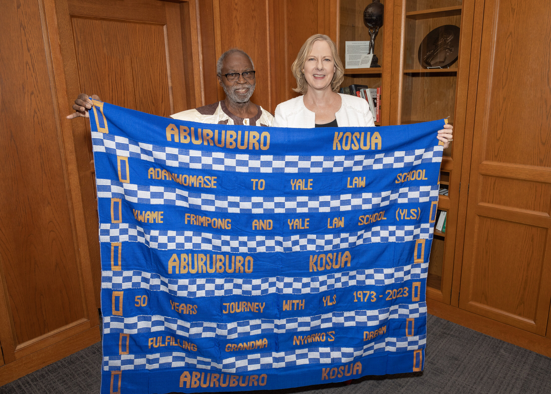 Kwame Frimpong ’74 LLM, ’77 JSD presents a kente cloth he made for Yale Law School to Dean Heather K. Gerken