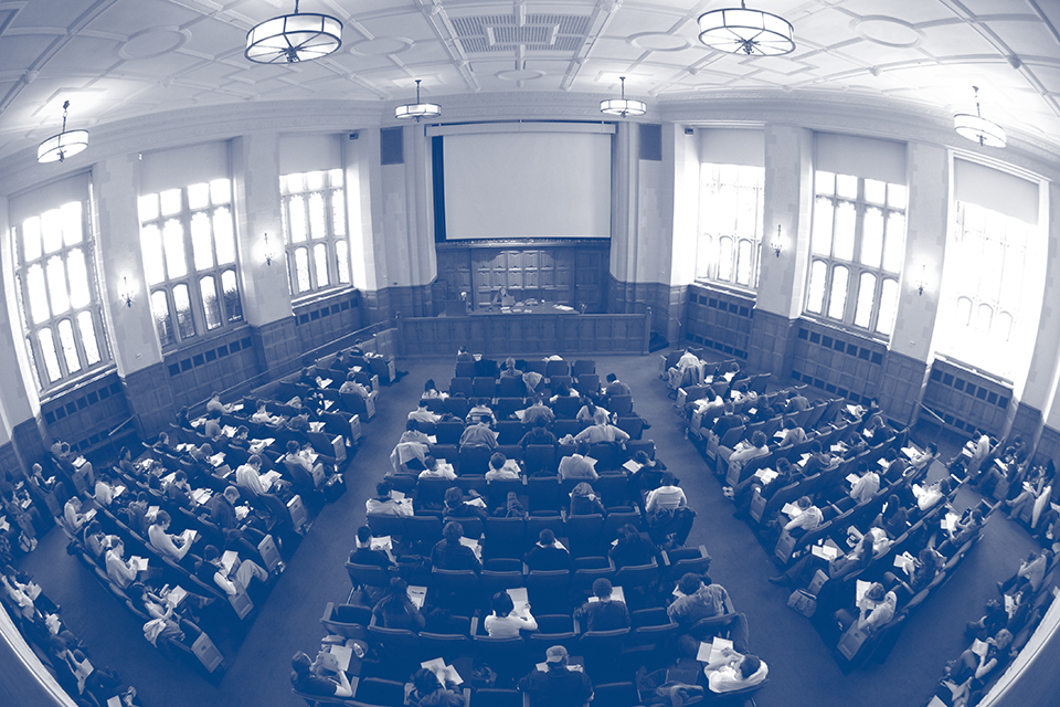 a blue-toned photograph of students in the Yale Law School auditorium