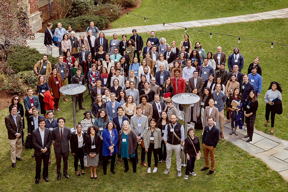 Liman fellows and colloquium attendees, a group of about 100 people, standing in a courtyard