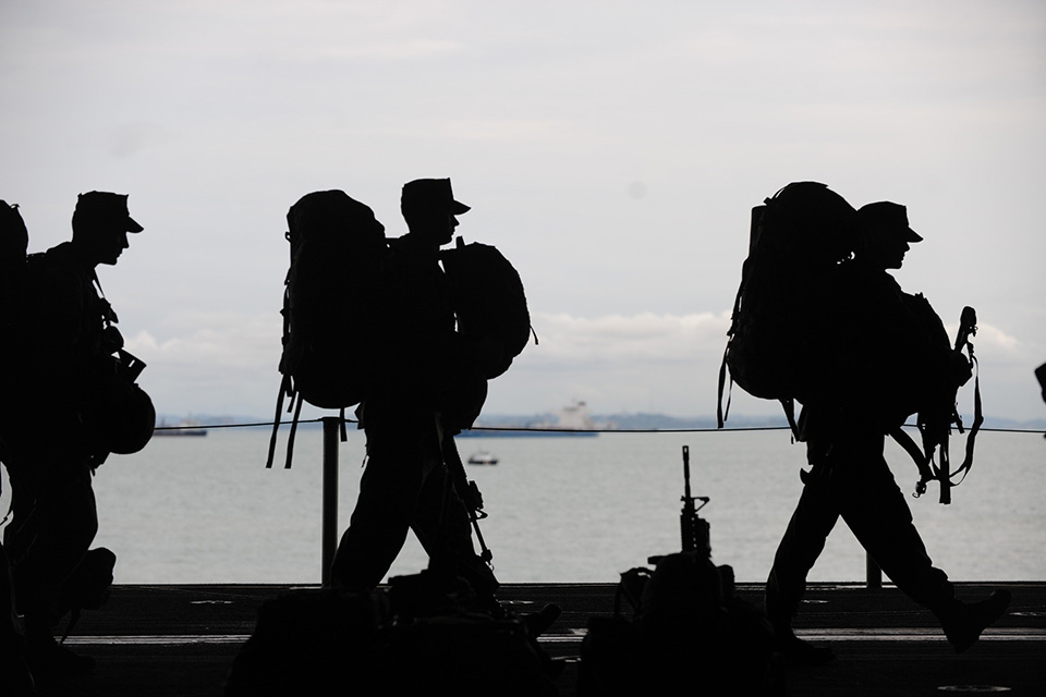 A group of soldiers walking, in silhouette