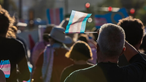 people marching holding transgender awareness flags
