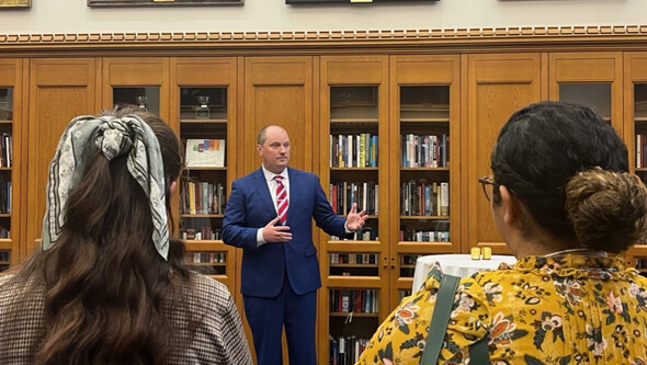 Rep. Jon Echols speaks to attendees in a wood paneled room