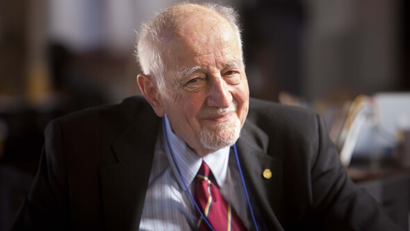 Guido Calabresi smiles with a soft focus office background