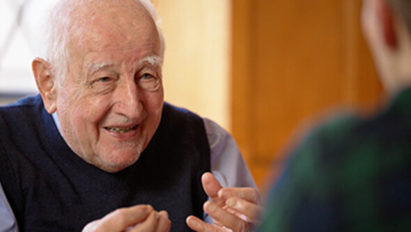 A close up of Guido Calabresi in conversation with his hands gesturing