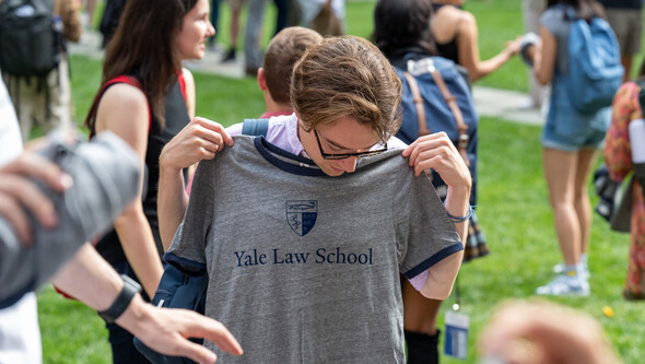 student holding up a YLS t shirt