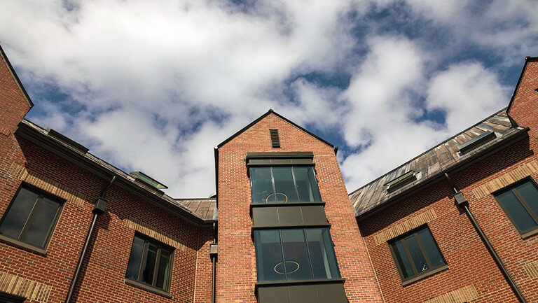 The upper floors of Baker Hall against a cloudy blue sky
