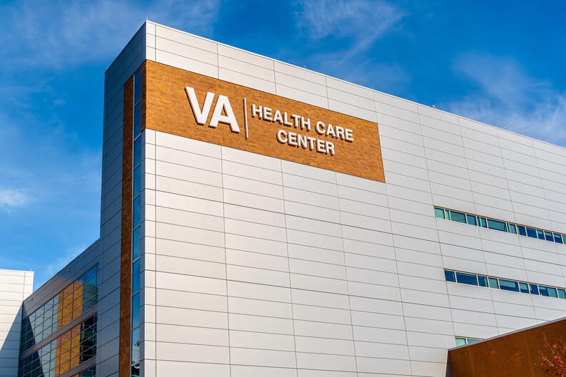 a modern building with the words VA Health Care Center against a blue sky