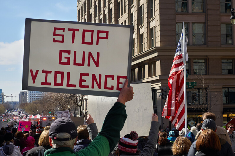 sign with the words Stop Gun Violence at a protest march