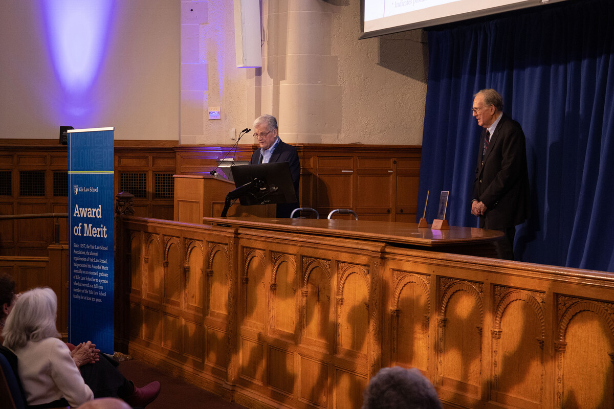 Denny Curtis and Steve Wizner on stage in front of a blue sign that says Award of Merit