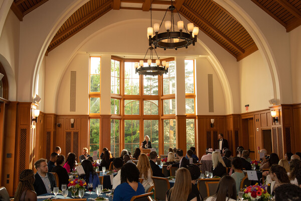 Dean Heather Gerken speaks to a group of people in a dining room at a commencement dinner