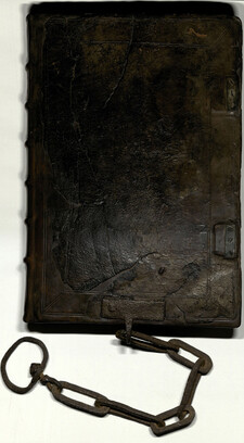 A notebook with a black leather cover and chain attached to the bottom