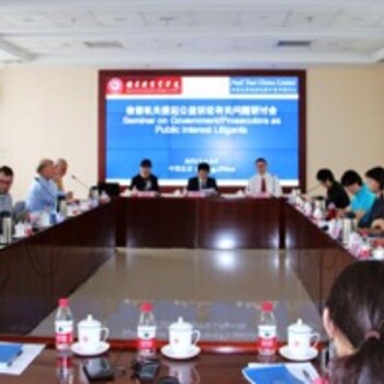 A wide shot of conference participants seated around a square table