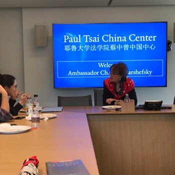 Ambassador Charlene Barshefsky seated in a classroom speaking to students with a video screen behind her reading Paul Tsai China Center