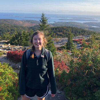 Sophie Laing ’21 outdoors with woodland and water views