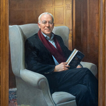 A portrait of Robert Post seated in a wing chair holding a book