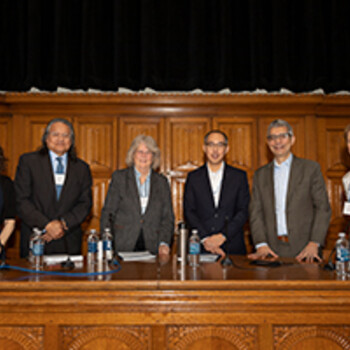 Liman panelist stand for a group photo on the stage in the law school auditorium