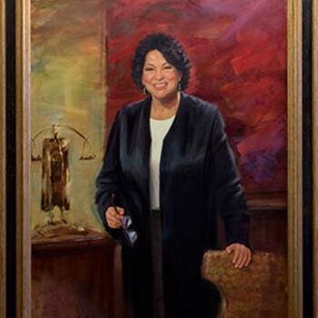 A painting depicted Sonia Sotomayor showing her posed in a black judicial robe holding a book in one hand and glasses in the other