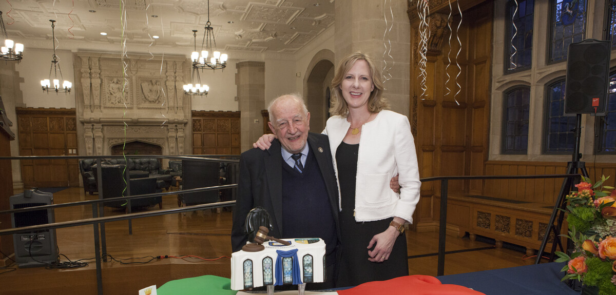 Guido Calabresi and Heather K. Gerken in front of a large cake shaped like Italy