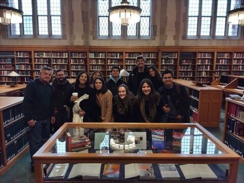 A group of students standing in front of a display case in the law library