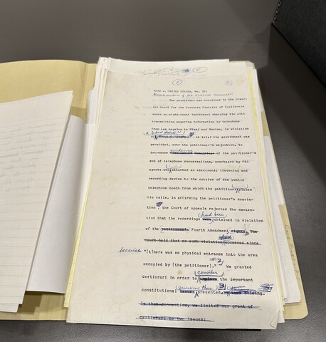 A stack of typewritten pages, including white and yellow lined paper, in a folder marked "Case Files. The top page reads "KATZ V. UNITED STATES" at the top and includes lines crossed out in blue ink and handwritten insertions.