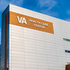 a modern building with the words VA Health Care Center against a blue sky
