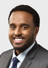Abdi Aidid smiles at the camera.