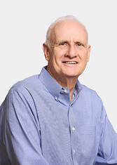 David Silberman in a blue shirt in front of a white background facing the camera.