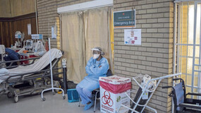 A healthcare worker rests in the hall where people 60 years and old are getting vaccinated with Pfizer vaccines, at Bertha Gxowa Hospital in Germiston. (Photo: Michele Spatari/AFP)