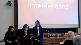 Debbie Rabinovich ’24, Sreya Pinnamaneni ’24, Manoela Saldanha ’25 standing in a classroom with below a screen showing the word "Intersections"
