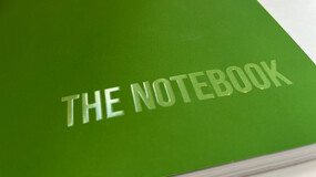 A book with a green cover and an embossed title "The Notebook"