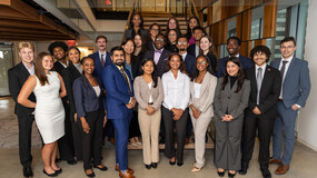 group of 25 new Launchpad Scholars standing in the lobby of a law firm