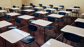 Rows of desks and chairs in a school classroom