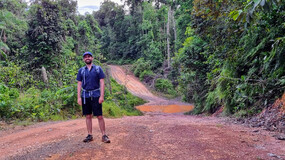 Jason Gardiner standing on a packed clay road through a wooded area