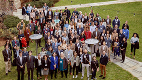 Liman fellows and colloquium attendees, a group of about 100 people, standing in a courtyard