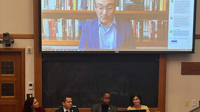 Duke Law School Professor Joseph Blocher (on screen) speaks at a Solomon Center panel. Seated below the screen in front of a chalk board were panelists were, from left, Senior Policy Advisor for the Philadelphia District Attorney’s Office Dana Bazelon, New Jersey Attorney General Matthew J. Platkin, and New York State Sen. Zellnor Myrie. Solomon Center Founding Directory Abbe Gluck’ 00, right, moderated