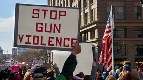 sign with the words Stop Gun Violence at a protest march