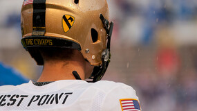 The back of a football player wearing a jersey that reads "West Point" and a gold helmet