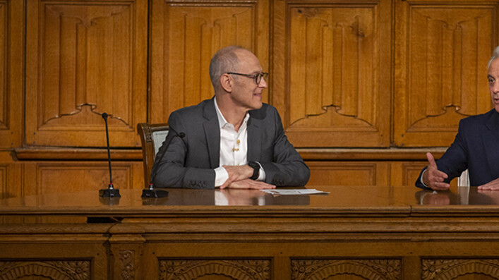 Ezekiel Emanuel and Rahm Emanuel seated at desk in lecture hall