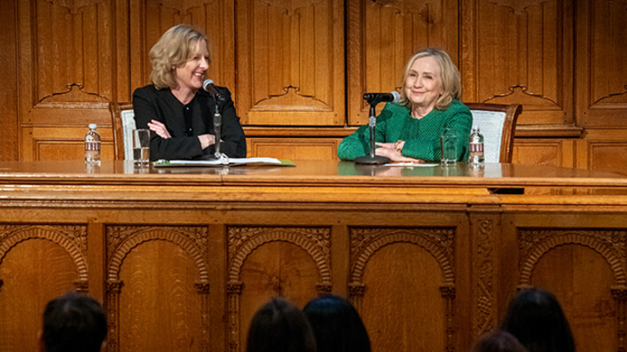 Dean Heather Gerken and Hillary Rodham Clinton seated at desk in front of lecture hall