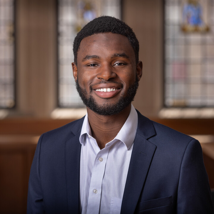 Chaka Tellem in a dark blazer and light shirt in a classroom with stained glass