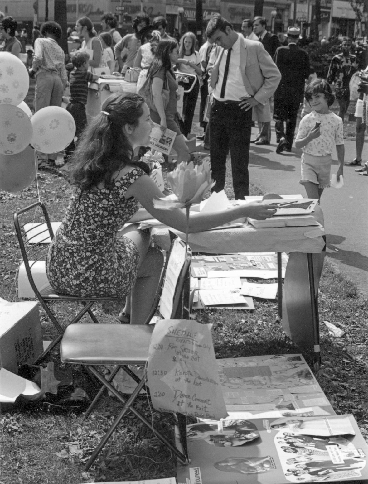 Gail Folk seated at a table on the New Haven Green in 1971