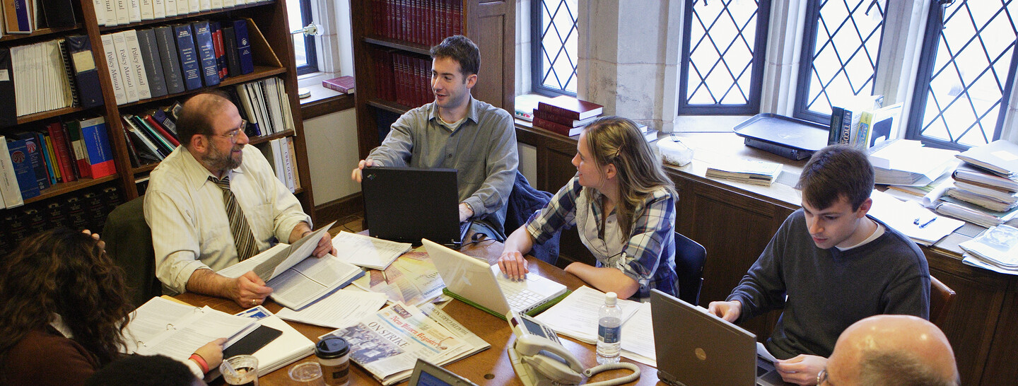 Professor Jay Pottenger with clinic students seated around a table