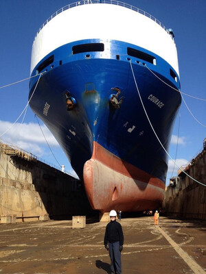 Kate Ahrens in front of a large ship in dry dock